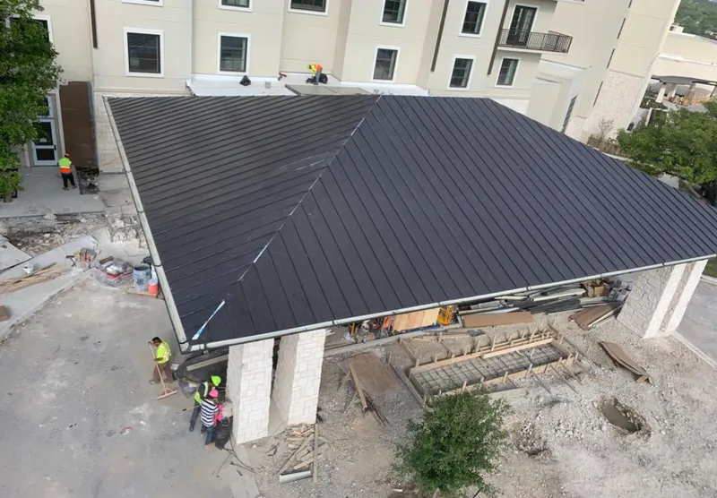 Metal roofing installation team working on a commercial building in Danville